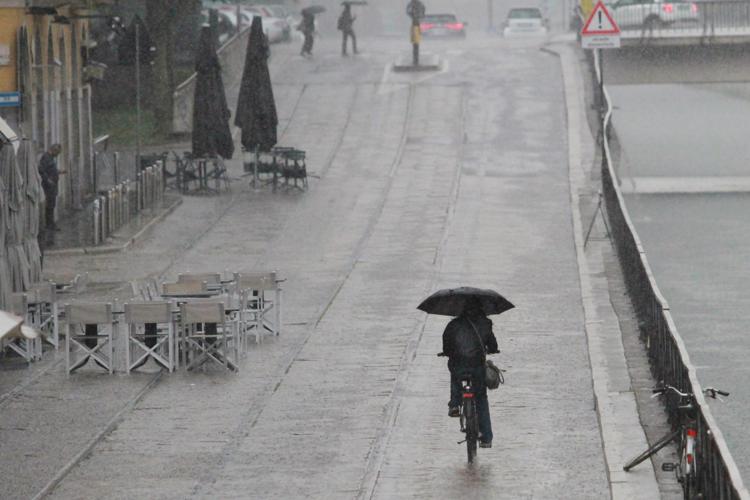 Uomo in bicicletta sotto la pioggia - (Fotogramma)