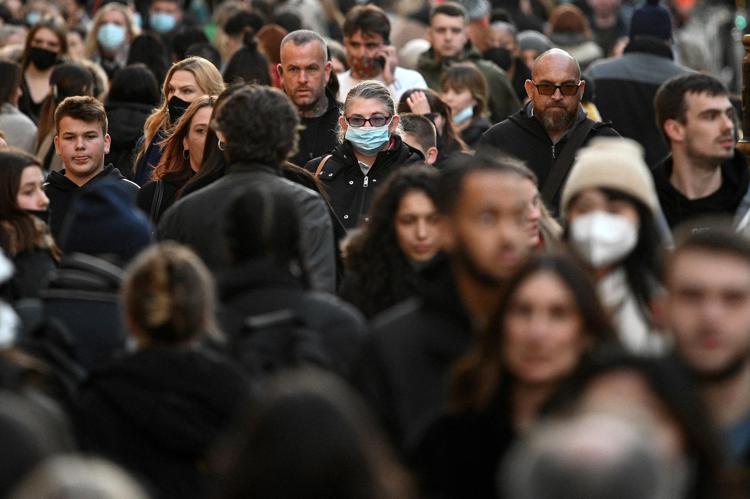 Shoppers, some wearing face-masks, walk along Oxford Street in central London on December 4, 2021, as compulsory mask wearing in shops has been reintroduced in England as fears rise over the Omicron variant of Covid-19. (Photo by Daniel LEAL / AFP)