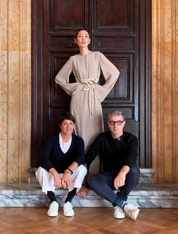 Lo stilista Vittorio Camaiani accanto alla moglie, ad una modella con un abito della sua ultima collezione  S/S 2024