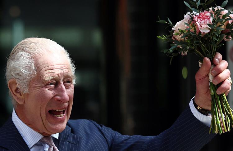 Re Carlo con in mano un mazzolino di fiori - Afp