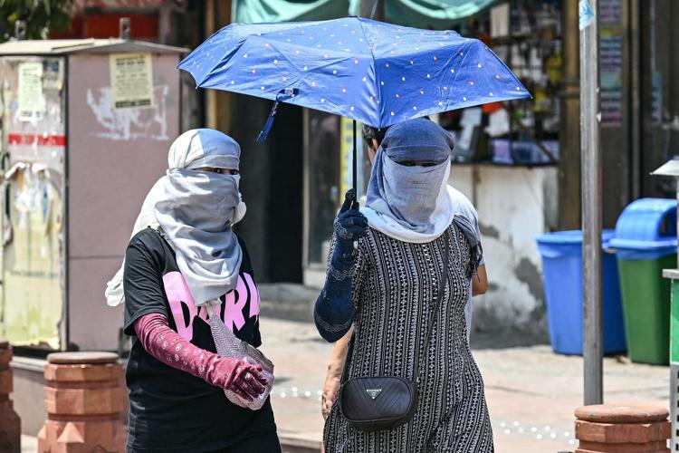 Donne a Nuova Delhi cercano di proteggersi dal caldo (Afp)