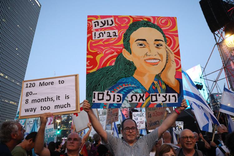 Un'immagine di Noa Argamani, uno dei quattro ostaggi israeliani salvati dall'esercito israeliano, viene sorretta da attivisti israeliani durante una manifestazione antigovernativa che chiede la restituzione degli ostaggi israeliani detenuti nella Striscia di Gaza  - (Afp)