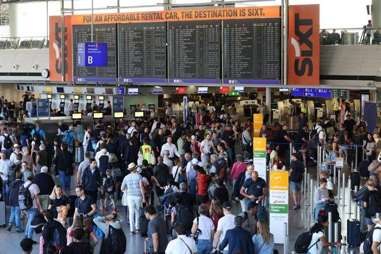 Passeggeri in fila oggi all'aeroporto di Francoforte (Afp)