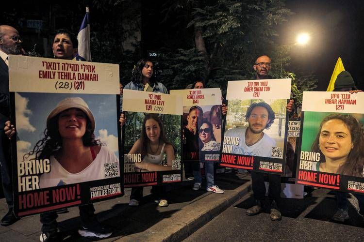 Manifestanti in piedi con i ritratti degli ostaggi israeliani - (Afp)