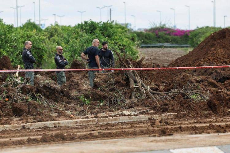 Servizi di sicurezza israeliani ispezionano un cratere vicino a una strada fuori dall'aeroporto israeliano Ben Gurion  - (Afp)
