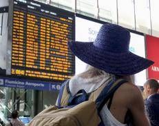 Passeggeri alla stazione Termini controllano il tabellone delle partenze - Ipa