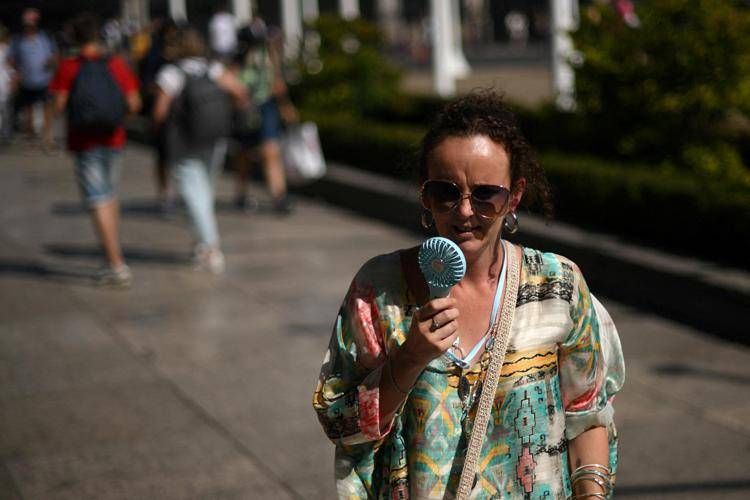 Una donna si rinfresca con ventilatore - (Afp)