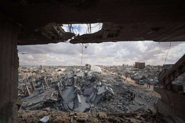 I palestinesi setacciano le macerie degli edifici tra le distruzioni causate dai bombardamenti israeliani a Khan Yunis, nella Striscia di Gaza meridionale, mentre il cessate il fuoco è in vigore dal 12 ottobre 2025 - Afp