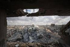 I palestinesi setacciano le macerie degli edifici tra le distruzioni causate dai bombardamenti israeliani a Khan Yunis, nella Striscia di Gaza meridionale, mentre il cessate il fuoco è in vigore dal 12 ottobre 2025 - Afp