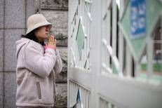Una madre prega fuori da un liceo di Seul mentre gli studenti sostengono l'esame annuale di ammissione all'università - (Afp)