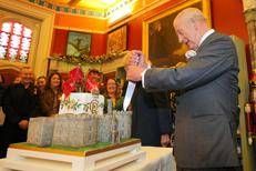 Re Carlo e la regina Camilla alle prese con una torta di compleanno a forma di castello, durante la visita in Galles del Sud - Ipa