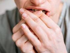 Una persona che si mangia le unghie