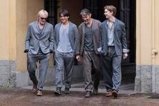 Alcuni capi della collezione uomo fw 2026 di Warped e a sinistra il fondatore del brand, Jack Williams