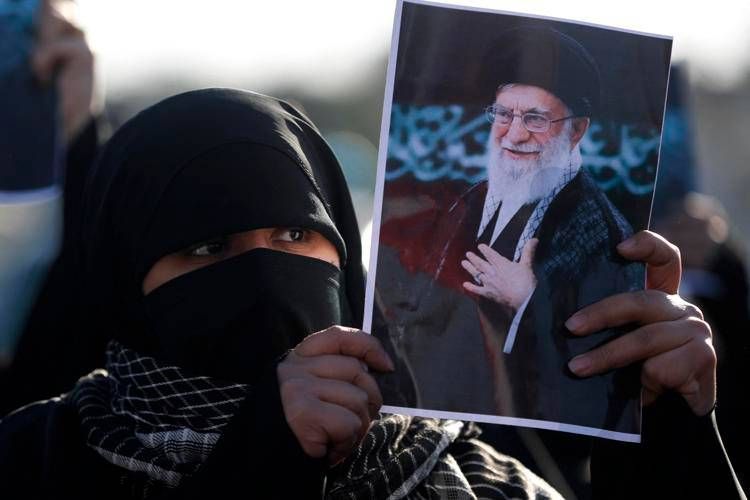 Manifestante con immagine di Ali Khamenei (Afp)
