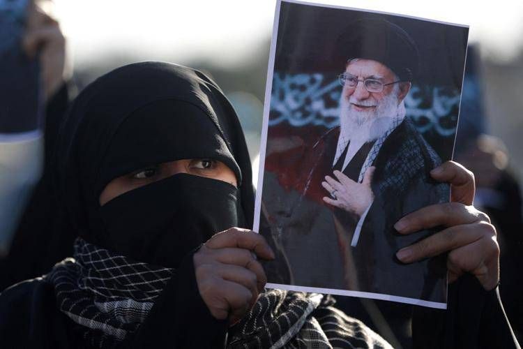 iran_donna_foto_khamenei_afp image Una donna con in mano la foto di Khameni, ucciso negli attacchi Usa-Israele all