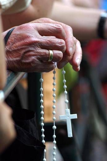 Un fedele sgrana un rosario (Fotogramma)