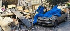 Un'auto di fianco a un edificio crollato oggi a Beirut, dopo i bombardamenti israeliani (Fotogramma/Ipa)
