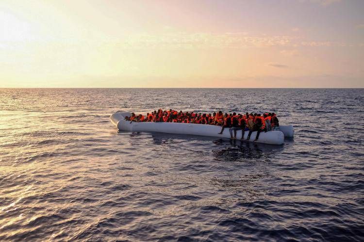 Alcuni migranti a bordo di un gommone  di fronte alle coste della Libia: la lotta al traffico di migranti è un pilastro del piano Ue per il Mediterraneo.  - Fotogramma/Ipa
