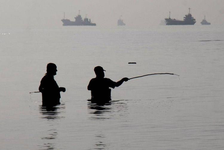 Alcuni uomini iraniani stanno pescando sulla spiaggia di Suru a Bandar Abbas, lungo lo Stretto di Hormuz - (Afp)