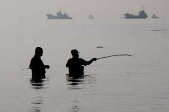 Alcuni uomini iraniani stanno pescando sulla spiaggia di Suru a Bandar Abbas, lungo lo Stretto di Hormuz - (Afp)