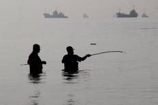 Alcuni uomini iraniani stanno pescando sulla spiaggia di Suru a Bandar Abbas, lungo lo Stretto di Hormuz - (Afp)