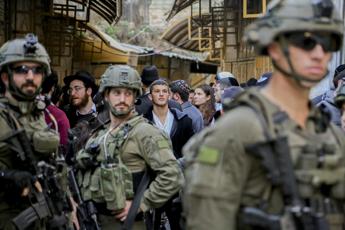 Coloni israeliani visitano il mercato di Hebron protetti dai soldati israeliani  - Fotogramma/Ipa