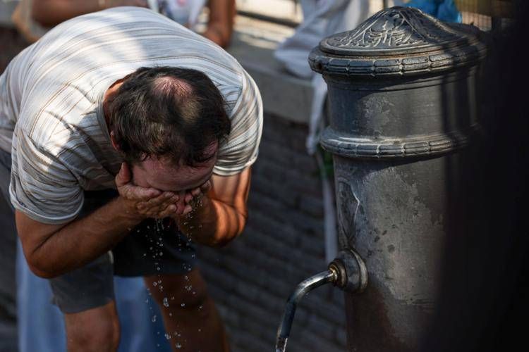 Uomo si rinfresca a un nasone a Roma - (Ipa)