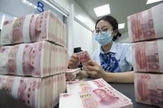 Un'impiegata di banca conta gli yuan (o renminbi) a Hai'an, nel Jiangsu, in Cina 
 - Fotogramma/Ipa
