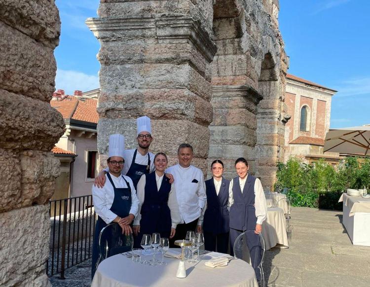 (Lo chef Emanuele Scarello assieme allo staff di Star Roof - Ufficio stampa Fondazione Arena di Verona)