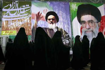 Iranian women walk by large posters of Ayatollah Khomeini and Iran's supreme leader Ayatollah khamenei in Tehran, Iran February 7, 2009.  On February 9, 2009, Iran will celebrate the 30th anniversary of Islamic Revolution founded by the late Ayatollah Khomeini. document IRAN/Yalda Moaiery - © document IRAN/Yalda Moaiery