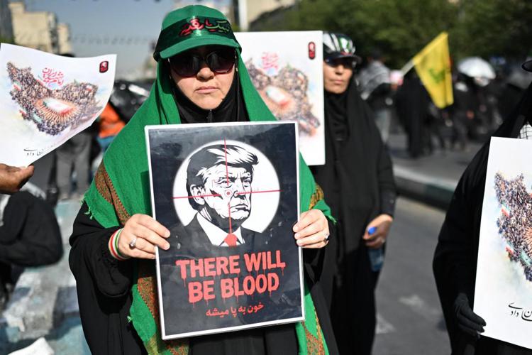 Donna in Iran con cartello contro Trump - (Afp)