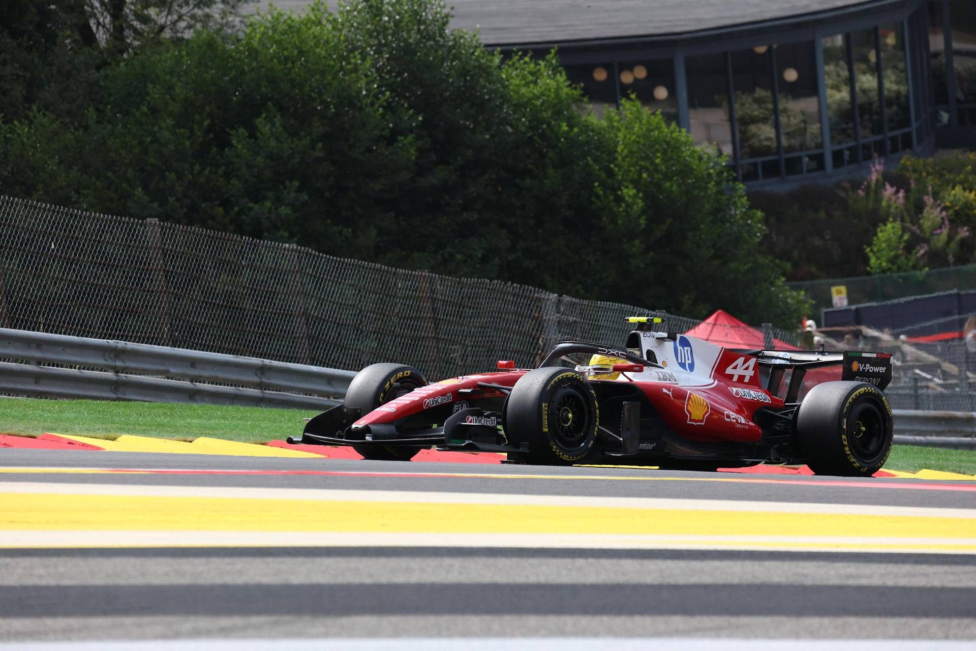 Pilota in tuta da gara al volante di auto da corsa su circuito veloce in sessione di prove