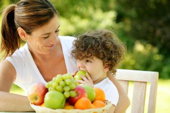 Bambina mangia la frutta - (123RF)