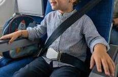 Un bambino con cintura allacciata su un aereo - (Foto creata con l'Intelligenza artificiale)