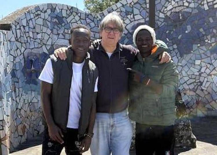 Don Massimo Biancalani con due migranti accolti dalla sua parrocchia - Foto dal profilo Facebook