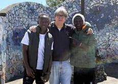 Don Massimo Biancalani con due migranti accolti dalla sua parrocchia - Foto dal profilo Facebook