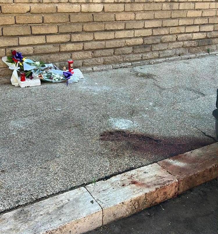 La chiazza di sangue davanti a fiori e candele