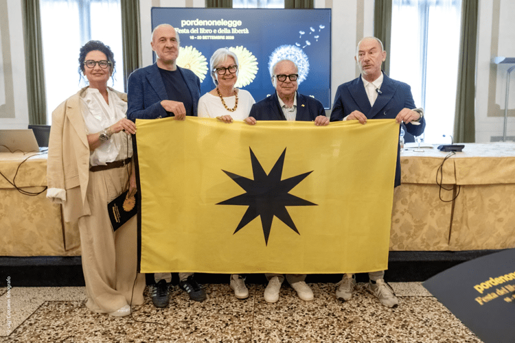 (Il vertice della Fondazione Pordenonelegge.it con la bandiera - Ufficio stampa del Festival)