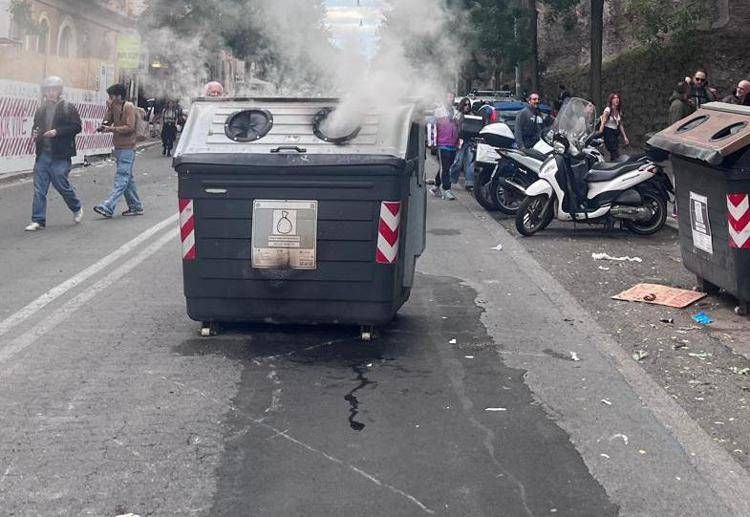Cassonetto a fuoco durante gli scontri a Roma. Foto Adnkronos