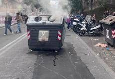 Cassonetto a fuoco durante gli scontri a Roma. Foto Adnkronos